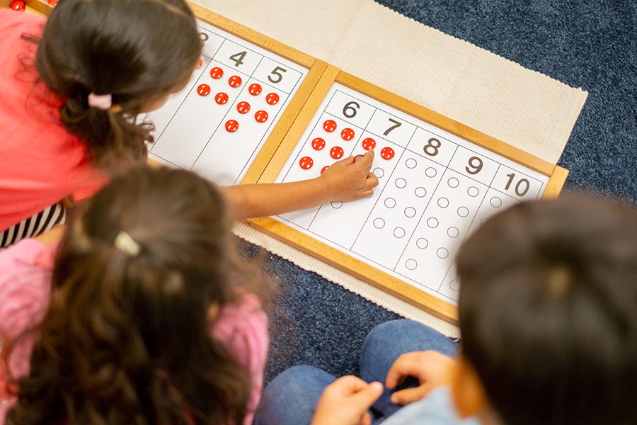 kids playing with a counting activity on the ground together