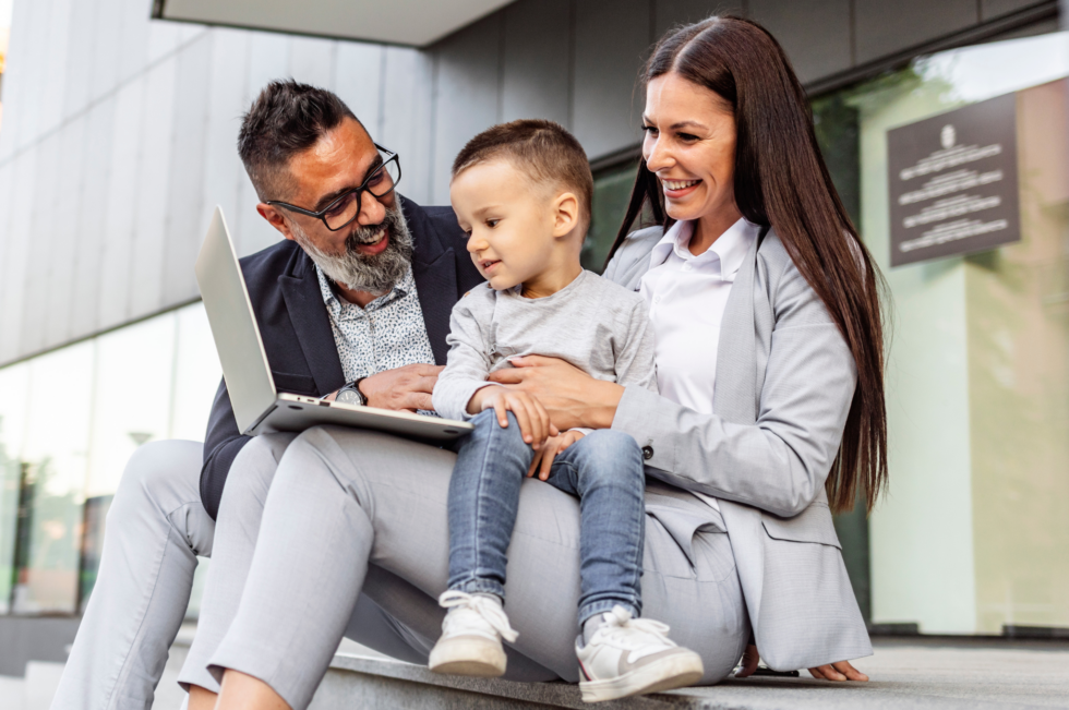 parents sitting with child looking at the computer