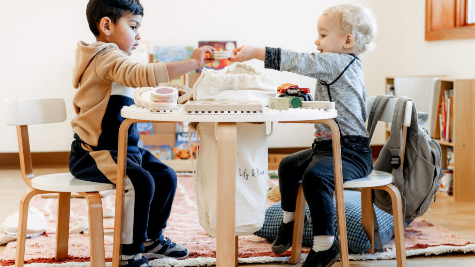 2 boys sharing a toy